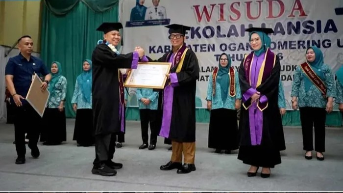 Bupati OKU Teddy Meilwansyah saat mewisuda lansia.