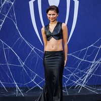 Zendaya mengenakan cropped vest kulit hitam dengan detail kancing di bagian depan. Atasan dipadukan dengan rok panjang dengan ekor menyapu lantai. Foto: Getty Images/Gerome Defrance