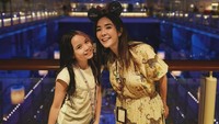 Menutup hari yang panjang dengan penuh kegembiraan, Gisel dan Gempi berpose di dek atas kapal saat malam hari. Gisel tampil memukau dengan gaun bermotif floral warna kuning cerah, dilengkapi dengan bando telinga Minnie Mouse berhias sequin merah. Gempi yang mengenakan kaus putih dan celana denim tak henti-hentinya tersenyum lebar. Latar belakang lampu-lampu kapal pesiar yang gemerlap menambah suasana magis. (Foto: dok Instagram gisel_la)