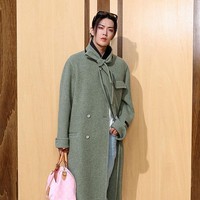Tak ketinggalan, ada Yuta NCT yang tampil standout dengan hand bag berwarna pink. Saat berpose di photo call spot, ia berbalut trench coat hijau yang klasik dengan detail dasi leher yang unik, serta kacamata hitam Louis Vuitton yang disematkan di atas kepala. Foto: Getty Images