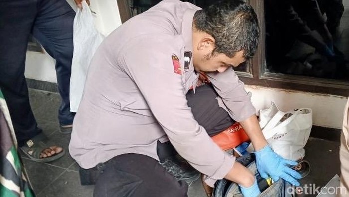Polisi saat melakukan olah TKP termasuk memeriksa tas bawaan korban
