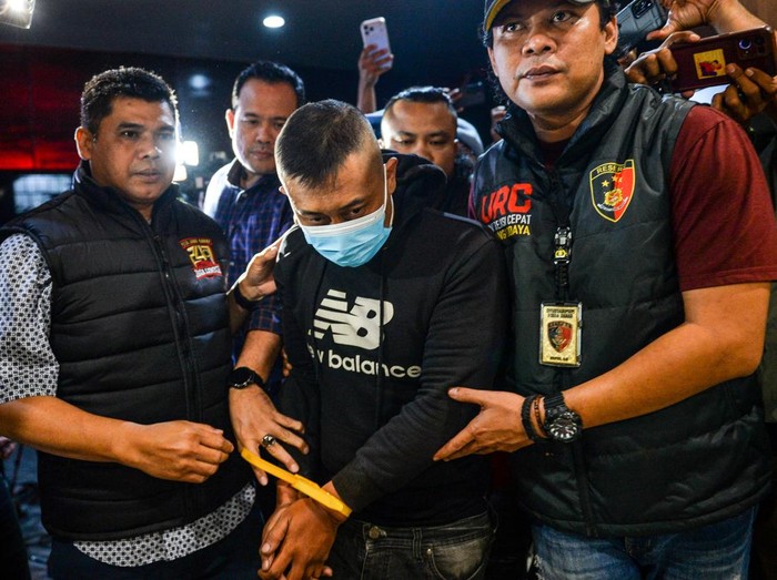 Petugas menggiring tersangka kasus dugaan penyekapan dan penganiayaan berat Taufik Hidayat (tengah) setibanya di Polda Jabar, Bandung, Jawa Barat, Selasa (23/6/2026). Polda Jabar menangkap Taufik Hidayat yang berstatus daftar pencarian orang di Kawas