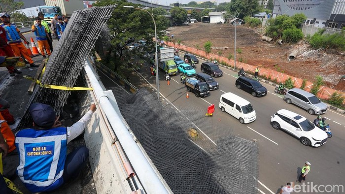Petugas mengevakuasi pagar besi wiremesh yang berserakan di Jalan Tol Jakarta–Tangerang, Jakarta, Rabu (24/6/2026).
