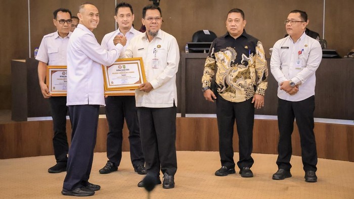 Foto: Plh Sekda Pekanbaru menerima penghargaan dari Kadiskominfotik Riau (Dok Pemko Pekanbaru)