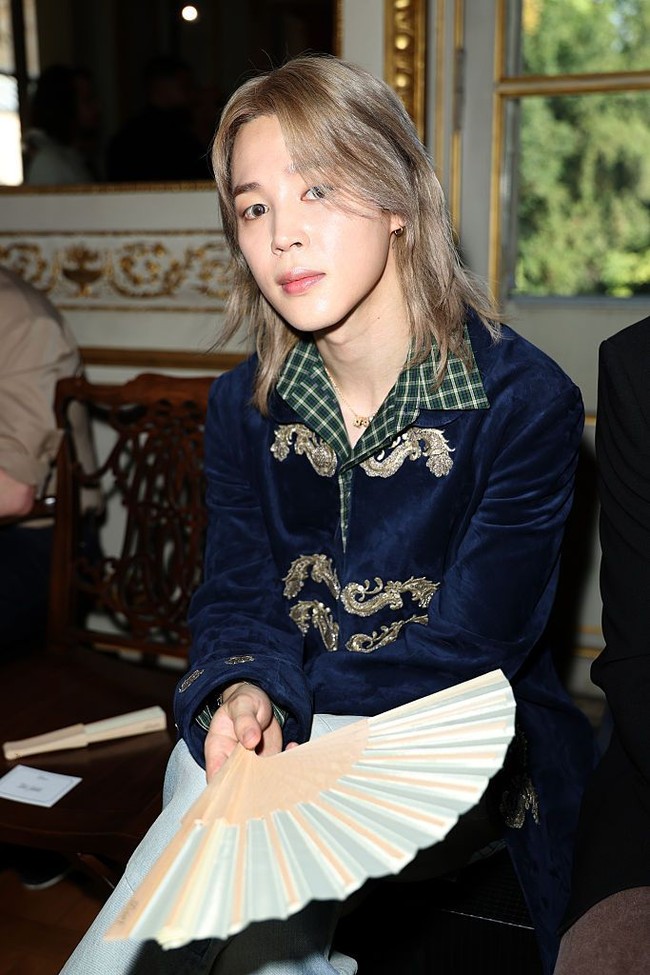 Detail look Jimin BTS turut menjadi sorotan. Di balik mantelnya, ia mengenakan kemeja kotak-kotak yang dipadukan dengan denim jeans dan sepatu boots coklat Dior Summer 2027. Foto: Getty Images