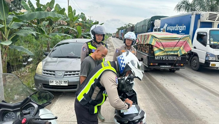 Polisi mengurai kemacetan parah di Jalan Lintas Timur, Pelalawan, Riau, pada Kamis (25/6/2026).