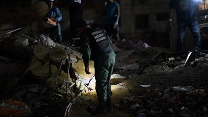 Rescuers and members of the National Guard work at the site of a collapsed building following an earthquake in Caracas on June 24, 2026. Two earthquakes of magnitude 7.2 and 7.5 struck the same area of Venezuela on the evening of June 24, causing bui