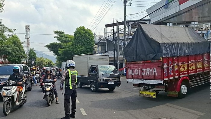 Petugas mengatur lalin saat antrean kendaraan di SPBU Kota Batu