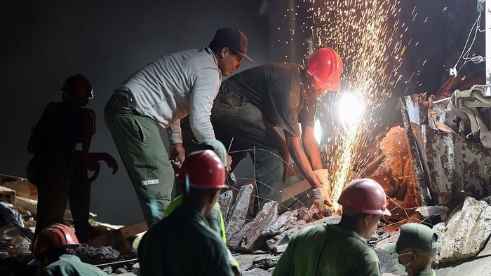 Tim SAR dan relawan berupaya mengevakuasi korban yang terperangkap di antara reruntuhan bangunan di Caracas, Venezuela, pada 24 Juni 2026 (Getty Images)