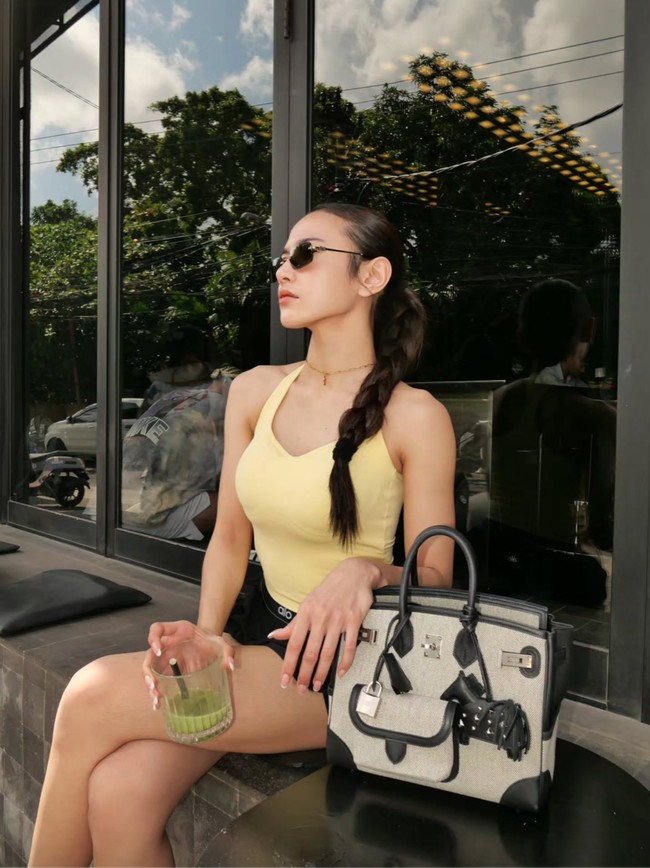 Rambut panjang Mahalini tampak dikepang rapi, membuat penampilannya terlihat clean. Yang tak kalah curi atensi ialah tas bernuansa abu-abu dan hitam yang diletakkan di sebelahnya. Foto: Threads/@mahaliniraharja