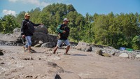 Dua petugas sensus melintasi aliran lahar hujan Gunung Semeru saat melaksanakan Sensus Ekonomi 2026 di Desa Sumberlangsep, Kecamatan Candipuro, Lumajang, Jawa Timur, Kamis (25/6/2026). Meski menempuh medan dengan akses jalan terbatas dan minim jaringan internet, petugas tetap melakukan pendataan secara akurat dan menjunjung etika statistik dalam pelaksanaan Sensus Ekonomi 2026 untuk menyediakan data dasar kegiatan usaha sebagai acuan penyusunan kebijakan pembangunan ekonomi. ANTARA FOTO/Irfan Sumanjaya  