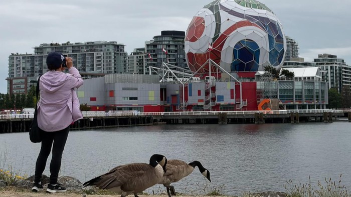 Warga berfoto dengan latar belakang instalasi raksasa berbentuk bola resmi Piala Dunia 2026 yang menghiasi gedung Science World di Vancouver, Kanada, Kamis (25/6/2026). Gedung ikonik tersebut dihiasi ornamen bertema Piala Dunia FIFA 2026 untuk menyemarakkan suasana kota selama berlangsungnya turnamen sepak bola terakbar dunia yang diselenggarakan bersama di Kanada, Meksiko, dan Amerika Serikat. ANTARA FOTO/Arif Prada/app/foc.