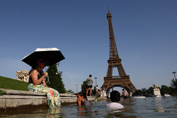 People cool off in the Trocadero fountain in front of the Eiffel Tower as temperatures rise in Paris during a heatwave affecting a large part of France, June 23, 2026. REUTERS/Abdul Saboor