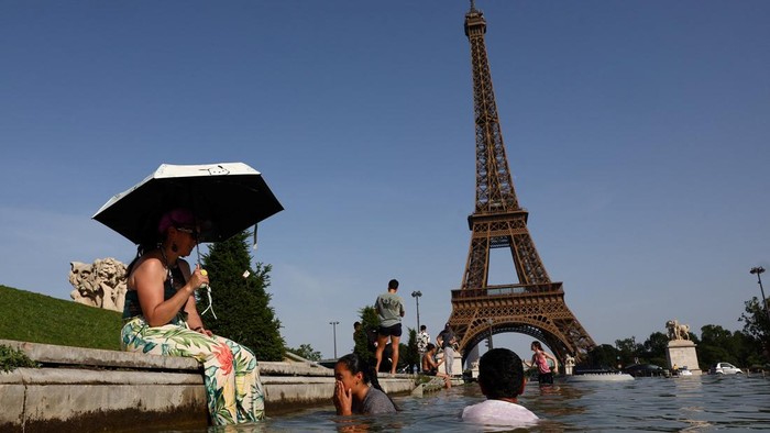 People cool off in the Trocadero fountain in front of the Eiffel Tower as temperatures rise in Paris during a heatwave affecting a large part of France, June 23, 2026. REUTERS/Abdul Saboor