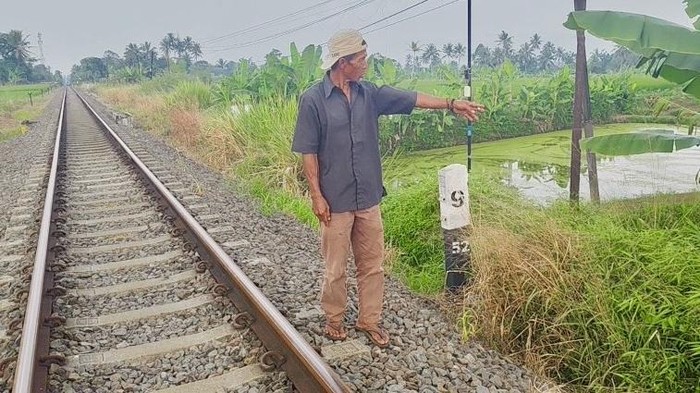 Warga saat menunjukkan lokasi kejadian lansia tewas usai terseret kereta api di Sukabumi