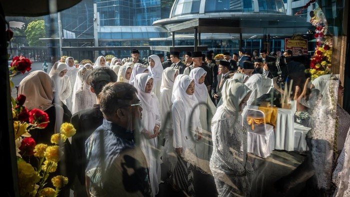 Pasangan pengantin menunjukkan buku nikah usai prosesi nikah massal pada Nikah Fest 2026 di Jakarta, Sabtu (27/6/2026). Kementerian Agama (Kemenag) menggelar program nikah massal yang diikuti 30 pasangan dari berbagai daerah di Indonesia sebagai upaya memberikan legalitas pernikahan yang sah sekaligus mendukung kemandirian ekonomi keluarga melalui pemberian bantuan modal usaha. ANTARA FOTO/Bayu Pratama S/hma
