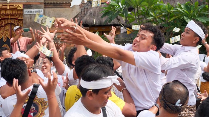 Warga berebut menangkap uang saat tradisi Mesuryak di Desa Bongan Gede, Tabanan, Bali, Sabtu (27/6/2026). Tradisi yang digelar setiap Hari Raya Kuningan tersebut diikuti ratusan pemuda dan warga desa setempat sebagai rasa suka cita untuk mengantarkan roh para leluhur kembali ke surga sekaligus mempererat kebersamaan keluarga dan masyarakat. ANTARA FOTO/Nyoman Hendra Wibowo/hma