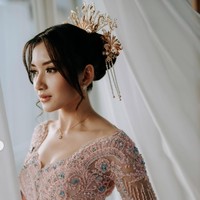 Penampilan Yuriska makin memukau dengan rambut tersanggul yang dilengkapi aksesori emas yang ditusukkan pada sanggulnya. Riasan wajah natural glam hasil tangan MUA Danika Davisca semakin memancarkan pesona cantiknya. Foto: Instagram/@asnawi_bhr