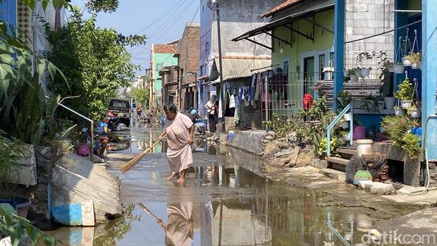 Warga saat menggosok jalanan yang terendam banjir rob  di Jalan Tambakrejo, Kelurahan Tanjung Mas, Kecamatan Semarang Utara, Kota Semarang, Minggu (28/6/2026).