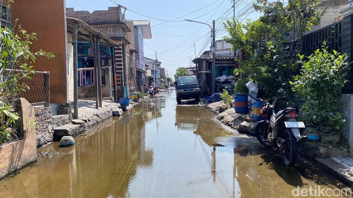 Warga saat menggosok jalanan yang terendam banjir rob  di Jalan Tambakrejo, Kelurahan Tanjung Mas, Kecamatan Semarang Utara, Kota Semarang, Minggu (28/6/2026).