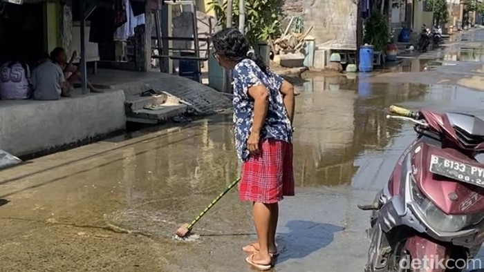 Warga saat menggosok jalanan yang terendam banjir rob  di Jalan Tambakrejo, Kelurahan Tanjung Mas, Kecamatan Semarang Utara, Kota Semarang, Minggu (28/6/2026).
