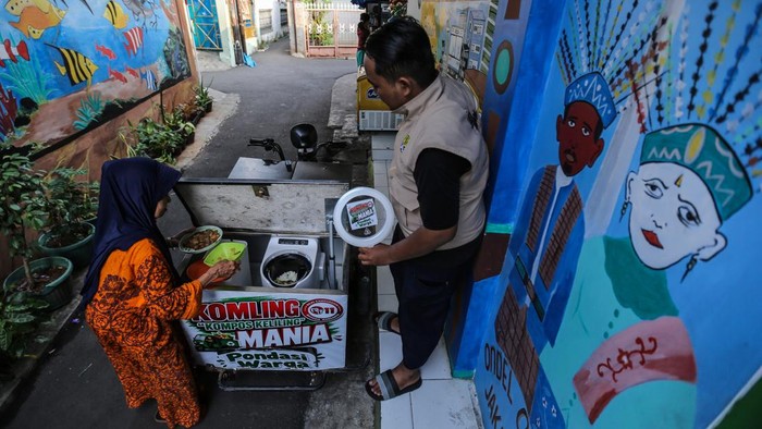 Petugas melayani warga yang membuang sampah organik ke dalam gerobak listrik Kompos Keliling (KOMLING) di RT11/RW07, Gandaria Utara, Jakarta Selatan, Minggu (28/6/2026). Masyarakat di wilayah RT11/RW07 Kelurahan Gandaria Utara, Jakarta Selatan membuat program KOMLING (Kompos Keliling) yang mampu mengelola sampah organik warga setempat guna mengurangi volume sampah sekaligus membantu menyelesaikan masalah sampah dari hulu.  ANTARA FOTO/Asprilla Dwi Adha/sgd