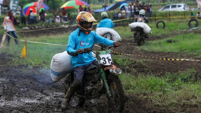 Pemanol (buruh angkut hasil panen) mengangkut karung gabah saat berpacu pada balap Manol Gabah Kapolresta Cup di Songgon, Banyuwangi, Jawa Timur, Sabtu (28/6/2026). Lomba yang digelar dalam rangka menyambut Hari Bhayangkara ke-80 tersebut diikuti 72 peserta yang mayoritas merupakan pemanol sebagai ajang hiburan sekaligus upaya melestarikan tradisi dan mempererat kebersamaan masyarakat tani menjelang musim panen. ANTARA FOTO/Budi Candra Setya/hma