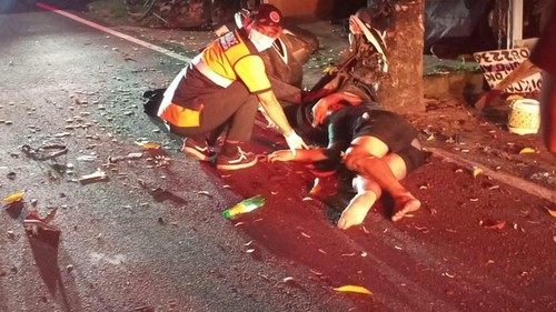Dua orang yang mengendarai motor menabrak pohon di Jalan Antasura, Denpasar, Minggu (28/6/2026).