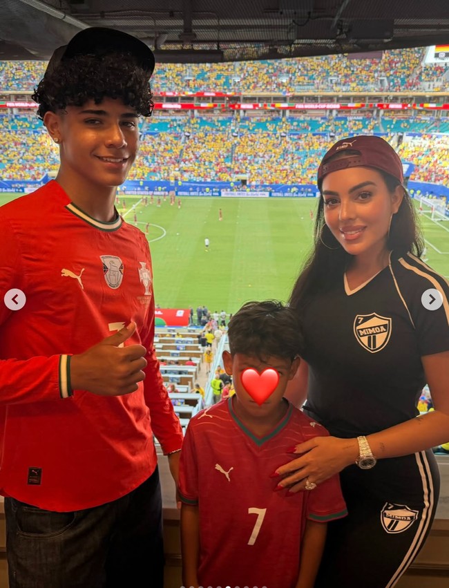 Kekasih pemain sepak bola profesional Portugal Cristiano Ronaldo, Georgina Rodriguez, tampak hadir menonton di Piala Dunia 2026. Georgina hadir bersama kedua anak Ronaldo. Georgina tampil simpel kenakan setelan bodycon berwarna navy. Foto: Instagram/@georginagio