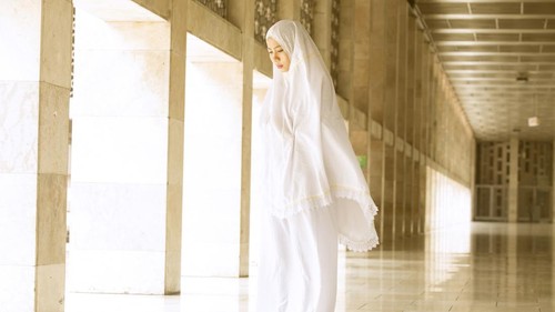 Young muslim woman doing salat in the mosque