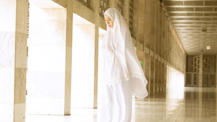 Young muslim woman doing salat in the mosque
