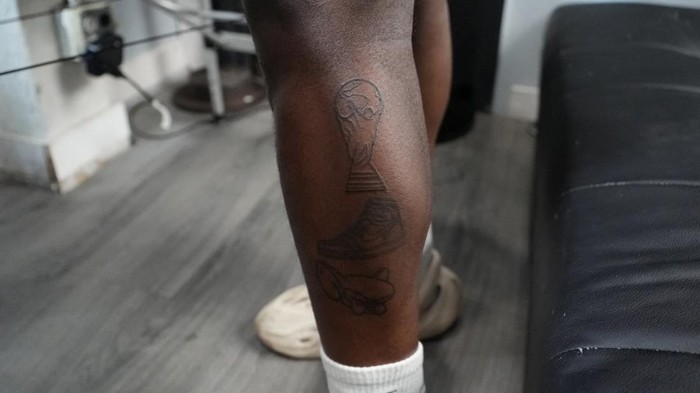 Lyric TheArtist tattoos a FIFA World Cup trophy on a person's leg, in Atlanta, Georgia, U.S. June 25, 2026. REUTERS/Jayla Whitfield-Anderson