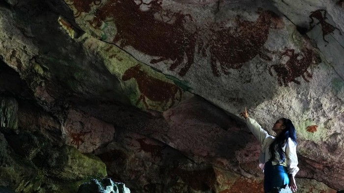 Pengunjung berada di bawah lukisan purba di dalam gua Metanduno di Desa Liang Kabori, Muna, Sulawesi Tenggara, Selasa (30/6/2026). Lukisan cadas purba di kawasan sekitar gua Metanduno tersebut diakui Guinness World Records sebagai karya seni gua tertua dan diperkirakan dikehidupan 67.800 SM dengan jumlah lebih 300 lukisan yang menceritakan perburuan di hutan dan lautan. ANTARA FOTO/Jojon/nz.