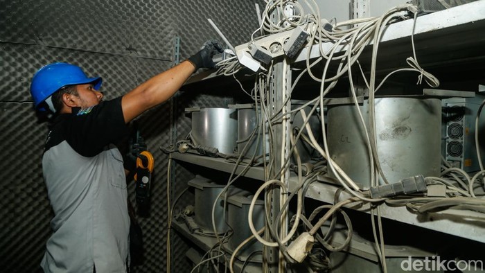 Petugas PLN dan kepolisian memeriksa server yang diduga untuk tambang bitcoin di Bekasi, Selasa (30/6/2026). Temuan tersebut bermula dari laporan warga saat berlangsungnya kegiatan penataan bangunan yang melebihi trotoar di sekitar lokasi. Ketika pen