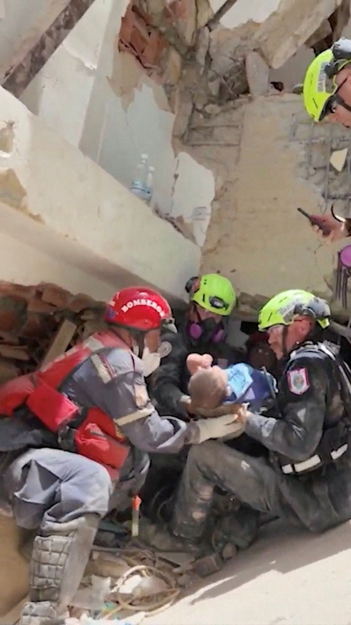 People clean a baby after rescuers pulled the child from the rubble of a collapsed building following deadly earthquakes that struck Venezuela on June 24, in La Guaira, Venezuela, in this screen grab obtained from a social media video released June 26, 2026. Andreina Quintero/via REUTERS  THIS IMAGE HAS BEEN SUPPLIED BY A THIRD PARTY. MANDATORY CREDIT. NO RESALES. NO ARCHIVES. OVERLAY FROM SOURCE.  Verification line: Reuters was not able to verify the location, but multiple sources and media confirmed it as La Guaira, Venezuela. Reuters was not able to verify the date, but no older version of the video was found online before June 26, and the date matches reports of a rescue in the area.