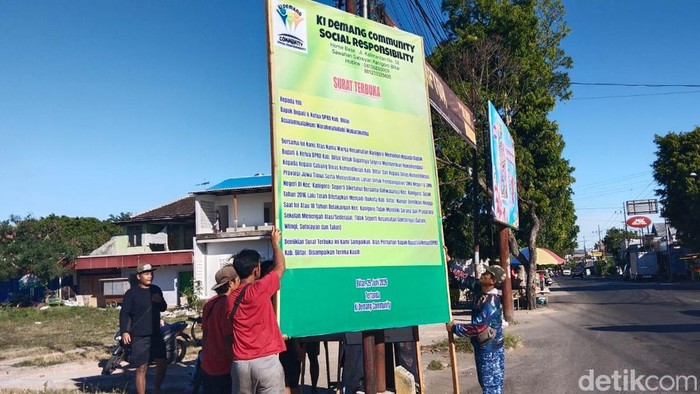 Warga memasang banner protes di Simpang Empat Kanigoro, Blitar