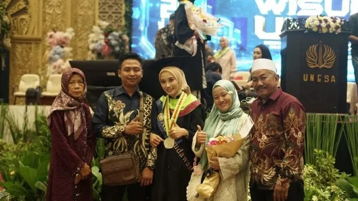 Fatimatuz Zahro (tengah) dan keluarga, wisudawan Unesa yang berhasil lulus S2 dengan IPK 4.00.