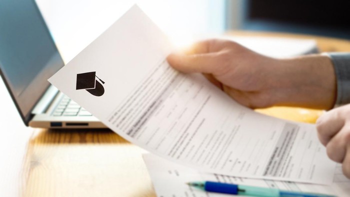 Man reading college or university application or document from school. College acceptance letter or student loan paper. Applicant filling form or planning studies.