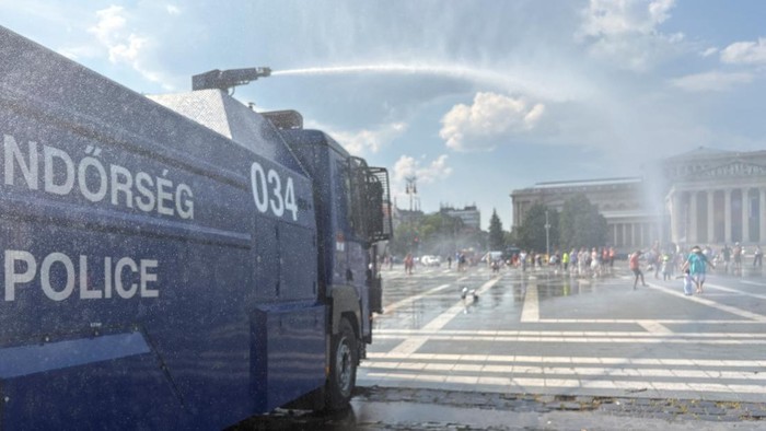 People enjoy as firefighters and police use water cannons to spray residents at Heroes Square to help them cool off during a severe heatwave in Budapest, Hungary, June 30, 2026. Picture taken with a mobile phone. REUTERS/Krisztina Fenyo