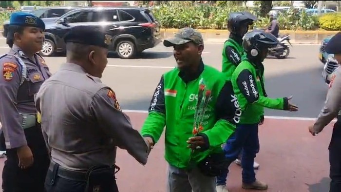 Momen ojol beri bunga ke polisi di Jakpus saat Hari Bhayangkara ke-80 (dok.istimewa)