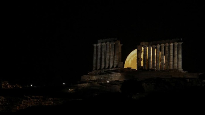 June's 'Strawberry' full moon rises over the ancient Temple of Poseidon at Cape Sounion, south of Athens, Greece, June 30, 2026. REUTERS/Louisa Gouliamaki