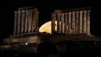 Fenomena bulan purnama Strawberry Moon atau Purnama Stroberi menghiasi langit Cape Sounion, Yunani. Cahaya bulan purnama tampak terbit di balik Kuil Poseidon, menciptakan pemandangan yang memadukan keindahan alam dengan warisan sejarah kuno. REUTERS/Louisa Gouliamaki