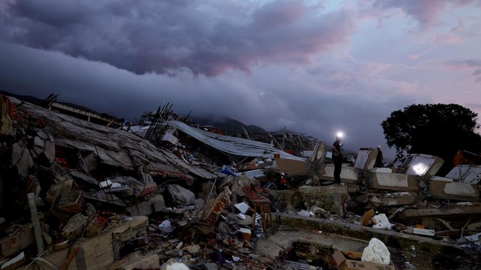 Yohancy Gil, 24 and her husband Sergio Guanipa, 30, stand on rubble as they wait for news from rescue teams looking for their children under the rubble at the site of a collapsed building in the aftermath of earthquakes, in La Guaira, Venezuela, June 30, 2026. REUTERS/Ricardo Arduengo  REFILE - QUALITY REPEAT     TPX IMAGES OF THE DAY
