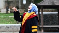 Kurangi bicara, lebih banyak gelar, tulis Uty Bonita dilihat di Instagram, Rabu (1/7/2026). Ini pose iconic orang-orang wisuda, yakni lempar topi yoga. (Foto: dok Instagram utybonita)
