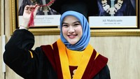 Menghadap kamera dengan senyum semringah, Uty Bonita tampil memesona mengenakan jubah wisuda bernuansa hitam-merah marun dengan kerah kuning dari Universitas Terbuka. Perpaduan hijab segi empat berwarna biru muda membuat wajahnya terlihat semakin cerah dan fresh di hari bahagianya. (Foto: dok Instagram utybonita)
