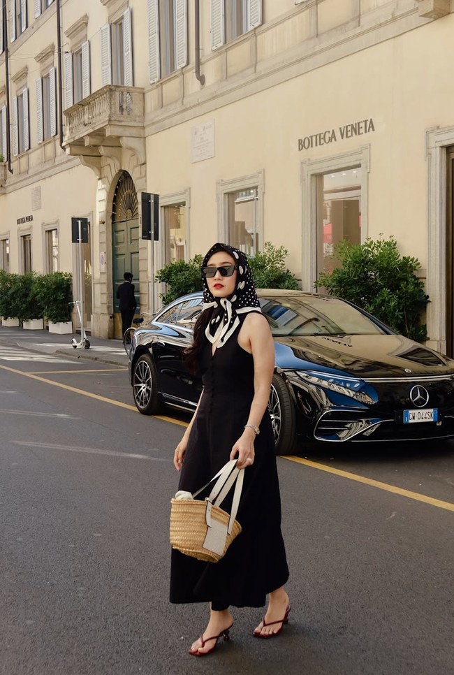 Salah satu look yang paling mencuri perhatian adalah saat Febby mengenakan dress hitam sleeveless dengan scarf motif di kepala. Dipadukan dengan woven bag dan sandal heels, gaya ini memberi nuansa old money. Foto: Instagram/@febbyrastanty