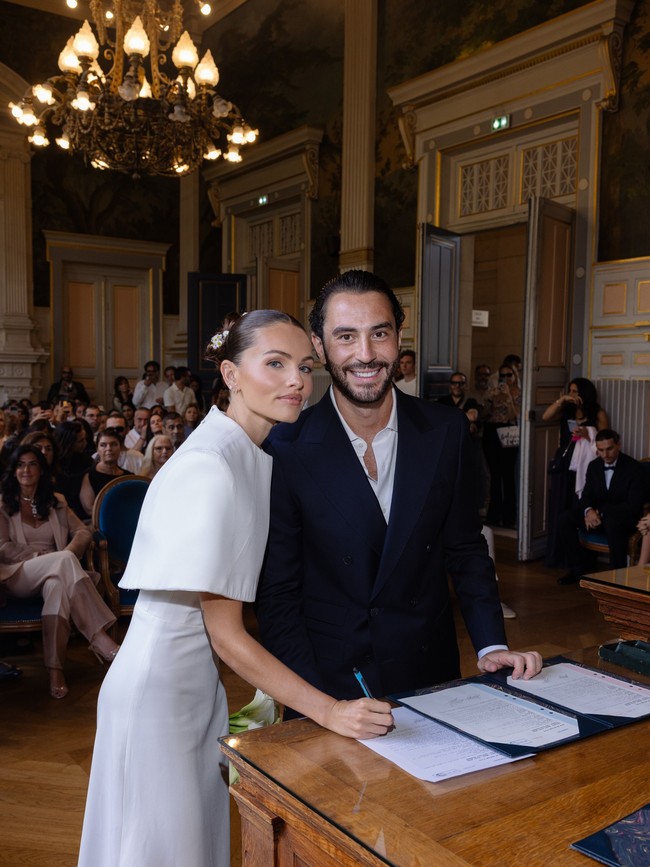 Rambut Thylane ditata dalam gaya sleek bun atau sanggul rendah yang rapi. Sanggulnya dihiasi bunga-bunga kecil berwarna putih sebagai aksesori manis yang memberi sentuhan romantis. Foto: Instagram/@thylaneblondeau