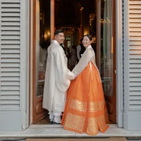 Meski dilangsungkan di Italia, suasana pernikahan Arden dan Chris tetap kental dengan budaya Korea Selatan. Kedua pengantin memakai hanbok alias baju tradisional Korea khusus rancangan rumah mode MeeHee, yang berbasis di Los Angeles. Dalam wawancaranya dengan Vogue Weddings, Arden mengungkap bahwa mereka juga mendorong tamu undangannya memakai hanbok. Foto: dok. Vogue Weddings