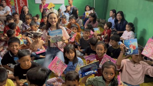 Audellya Ambara saat membagikan buku bacaan bahasa Inggris.