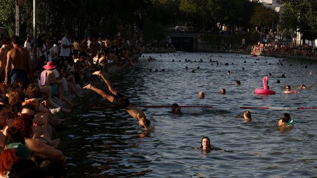 People swim in the Canal Saint-Martin after public swimming was permitted in certain areas due to high temperatures amid a heatwave in Paris, France, June 26, 2026. REUTERS/Tom Nicholson